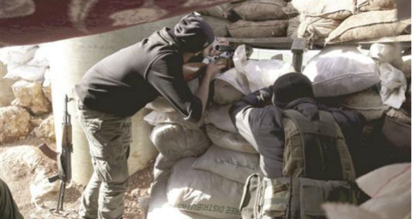 مسلحان من «أحرار الشام» خلال الاشتباكات مع الجيش السوري في إدلب أمس (رويترز)