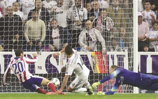 مهاجم «ريال مدريد» المكسيكي هرنانديز (في الوسط) يسجل هدف الفوز في مرمى حارس «أتلتيكو مدريد» السلوفيني أوبلاك ومدافع خوانفران (أ ف ب)
