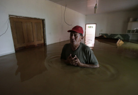 رجل يقف داخل منزله الذي غمرته مياه الفيضانات في البرازيل