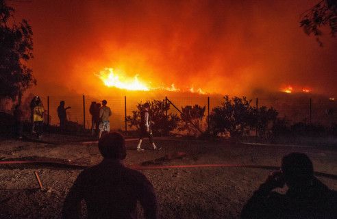 أشخاص يشاهدون حرائق اندلعت في غابات شمال العاصمة اتشيلية