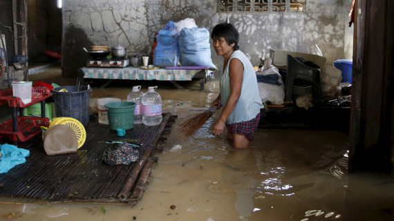 امرأة تمسك مكنسة داخل منزلها المغمور بمياه الفيضانات في الفيلبين