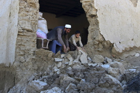 رجل مع ابنه يخرجان أنقاضا من منزلهما بعد زلزال وقع في إحدى مناطق أفغانستان