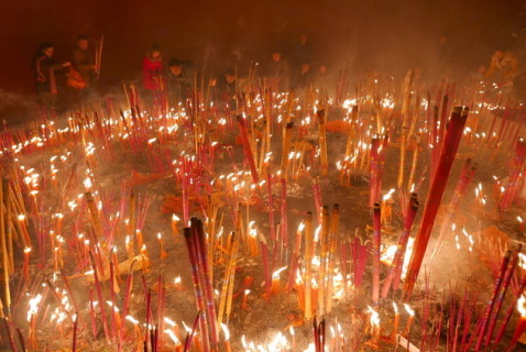 مؤمنون يحرقون البخور في أثناء صلاتهم في اليوم الأول من السنة القمرية الصينية الجديدة