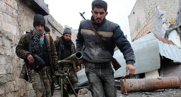 Opposition fighters carry a rocket launcher during clashes against government forces in the Sheikh Lutfi area, west of the airport in the northern Syrian city of Aleppo on January 27, 2014. Fighting inside Syria has continued unabated as opposition and regime representatives meeting in Geneva discussed ways for aid to reach besieged rebel-held areas, especially in the central city of Homs. AFP PHOTO / SALAH AL-ASHKAR        (Photo credit should read SALAH AL-ASHKAR/AFP/Getty Images)