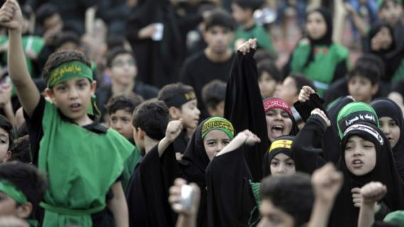 أطفال يشاركون في مراسم السعوديين الشيعة لإحياء ذكرى عاشوراء في مدينة القطيف الساحلية