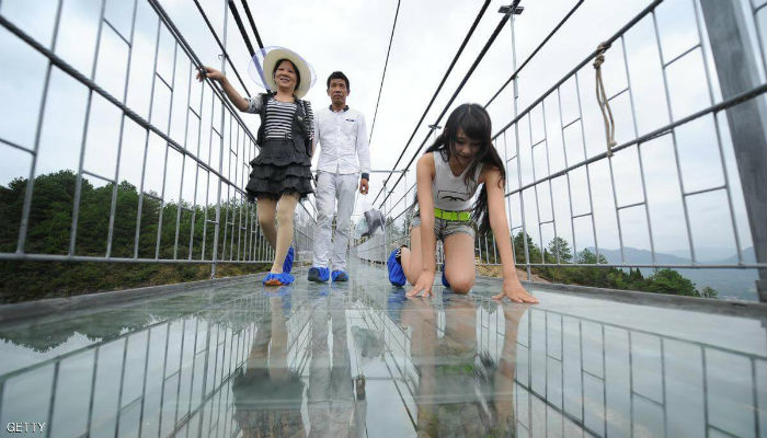 فتاة تتأمل الجسر الزجاجي المخيف في الصين