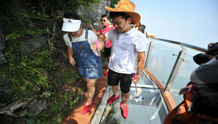 خوف الزوار من المشي عل الجسر الزجاجي المخيف في الصين