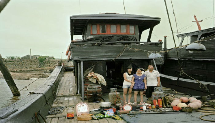 صورة لعائلة صينية مع كافة أغراضهم المنزلية خارج اليخت 