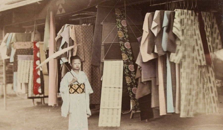 طفلة يابانية تقف أمام محل ألبسة