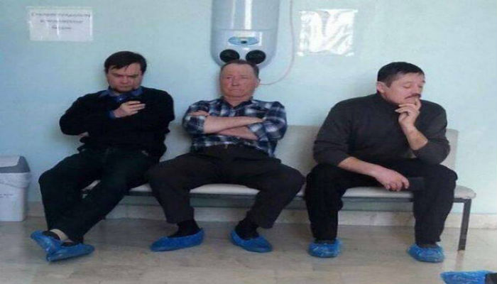 ثلاثة رجال جالسون في مستشفى وصورة للرجل الذي في الوسط بلحظة مضحكة 