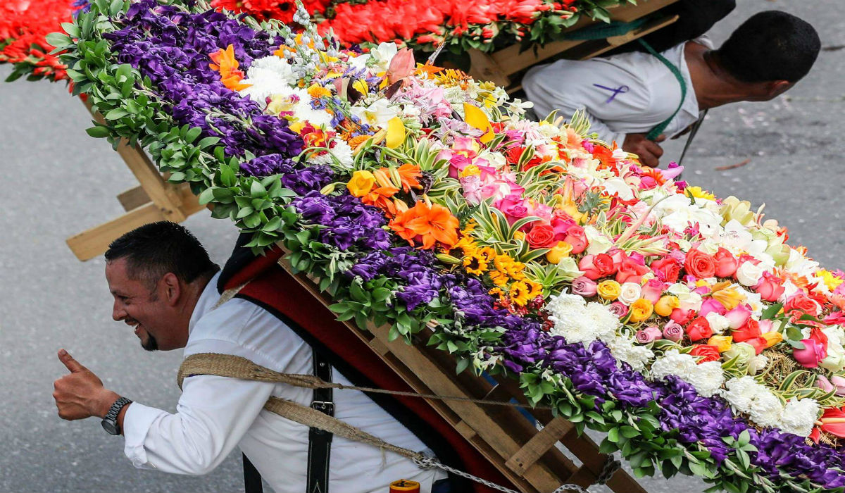 الرجلان يحملان الزهور على ظهرهما في مهرجان الزهور في كولومبيا