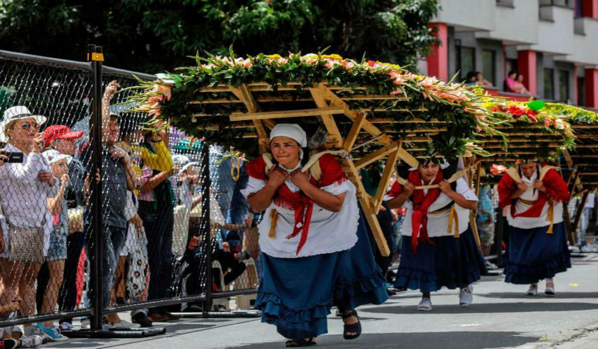 نساء يحملن باقات ورود عملاقة في موكب مهرجان الزهور السنوي في كولومبيا