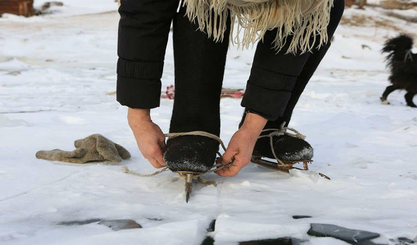 الجدة «ليوبوف مورخودوفا» تربط حذاء التزلج كي تتزلج على جليد بحيرة بايكال في سيبيريا