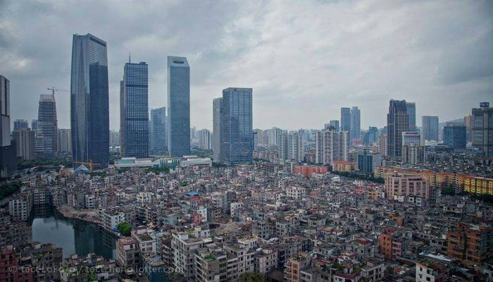 القرى الحضرية في الصين والأبنية الشاهقة في المدينة المجاورة لها 