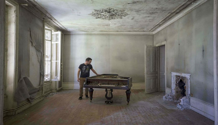 صورة فوتوغرافية للفنان «رومان ثيري» بجانب بيانو منسية في أحد المنازل الأوروبية المهجورة