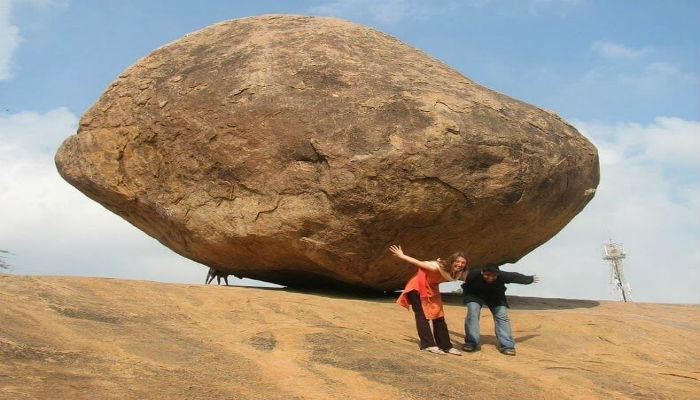 أحد السياح يلتقطون الصور بجانب صخرة كريشنا العملاقة التي تتحدى الجاذبية