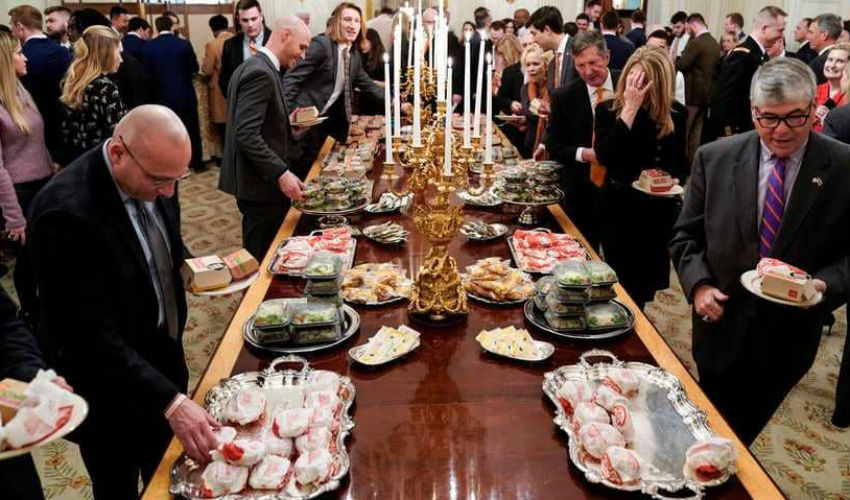 مأدبة طعام في البيت الأبيض على نفقة ترامب، تتوسطها شمعدانات ذهبية كبيرة. 