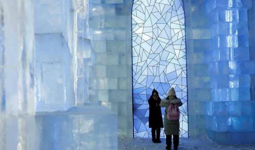 الزوار يتصورون داخل إحدى قصور الجليد في مهرجان "هاربين" في الصين.