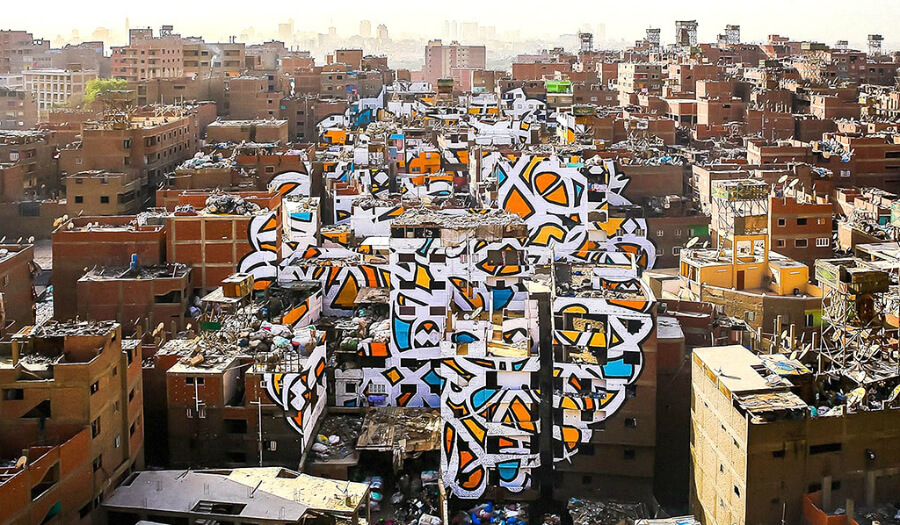 صورة للوحة مشروع "سلام" الفنية والمميزة على جدران 50 مبنى في حي منشية ناصر بالقاهرة، وتحوي كتابة "إن أراد أحد أن يبصر نور الشمس فإن عليه أن يمسح عينيه"-للفنان التونسي "السيد".