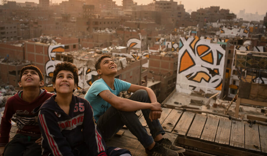 الأولاد على أسطح حي منشية ناصر بالقاهرة يتمتعون بمنظر اللوحة المميزة التي صممها الفنان التونسي "السيد" مع فريق مؤلف من 40 شخصاً.