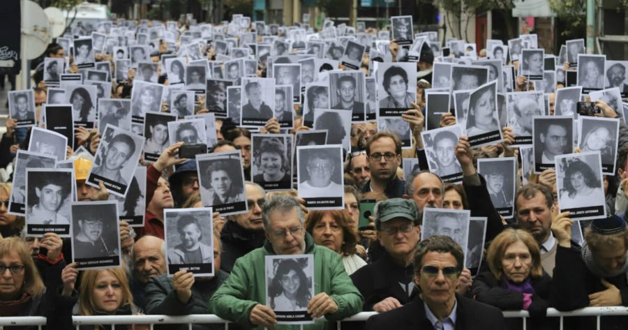 عائلات مع صور لضحايا الهجوم على مركز أميا في الأرجنتين