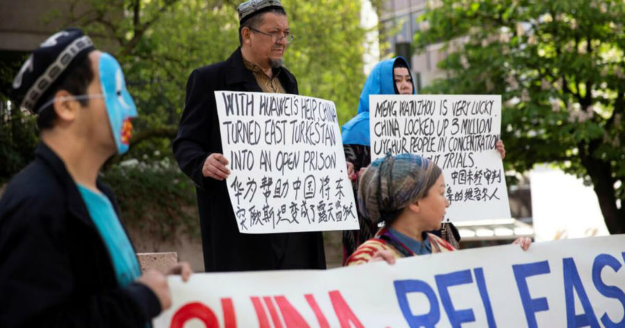 أشخاص يرفعون لافتات في كندا يوم 8 أيار 2019 ضد معاملة الصين لأقلية الويغور في منطقة شينجيانغ