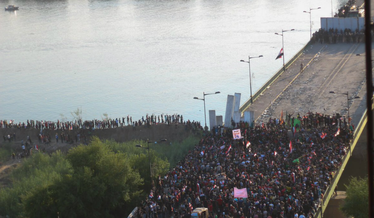 متظاهرون عراقيون فوق جسر الجمهورية يحاولون اقتحام المنطفة الخضراء والجيش يتصدى لهم