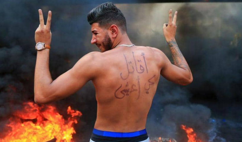 متظاهر كتب على ظهره شعار "أقاتل كي أعيش"