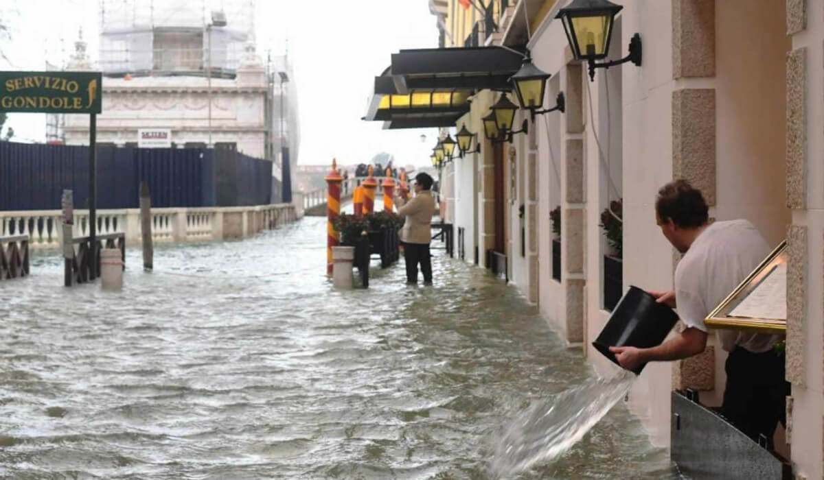 رجل يحاول افراغ المياه التي تجمعت داخل منزله جراء فيضان فينيسيا