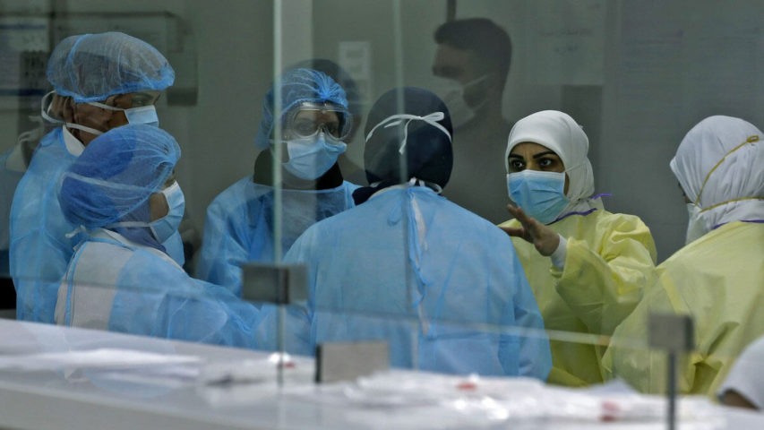 ممرضون يعالجون المرضى الذين يعانون من فيروس كورونا في مستشفى رفيق الحريري (جوزيف عيد/ أ.ف.ب)