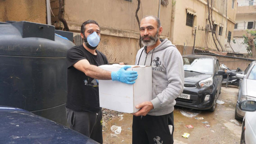 شبل ياسين، من مجموعة "منشرين" يوزع المساعدات لمواجهة تداعيات انتشار كورونا في حي السلم (The National)