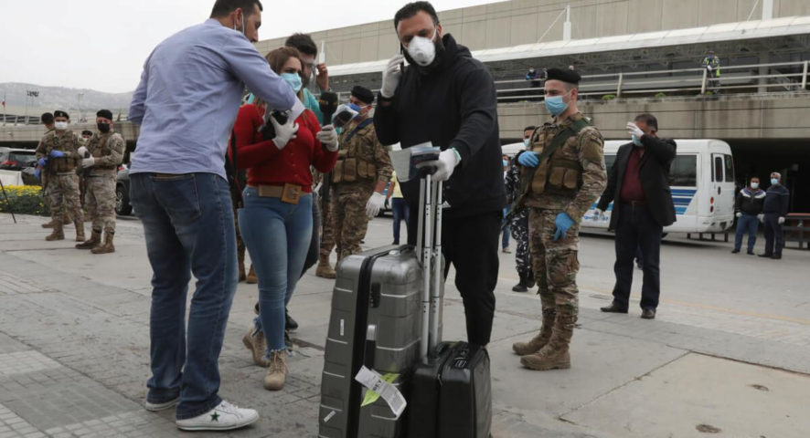  يرتدي قناع وجه وقفازات وهو يحمل أمتعته لدى وصوله إلى مطار رفيق الحريري الدولي (رويترز) 
