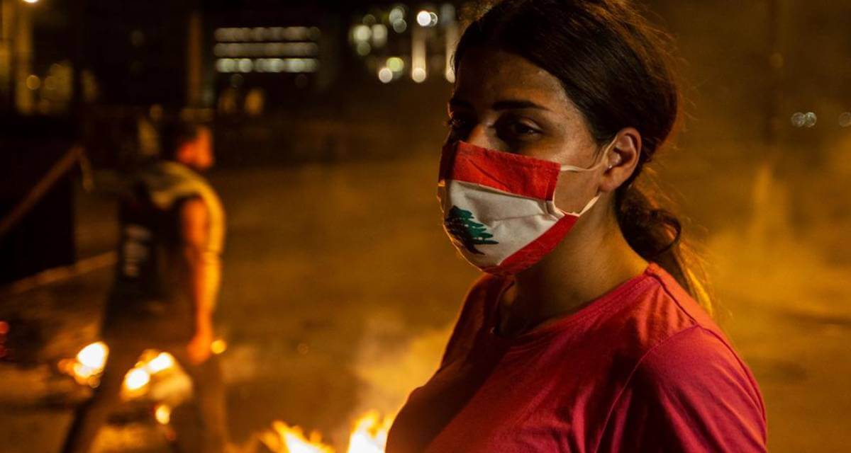متظاهرة تضع كمامة للوقاية من فيروس كورونا مع عودة التظاهرات الى لبنان (EPA)