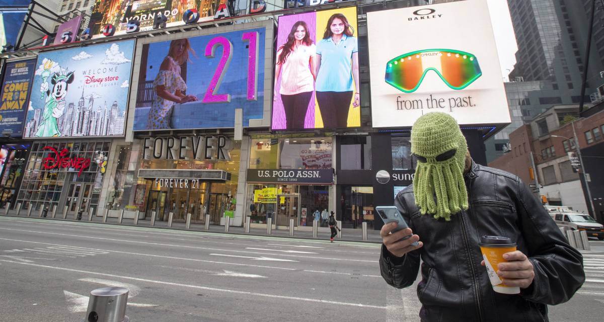 رجل يضع قبعة أخطبوط لصد فيروس كورونا في تايمز سكوير في نيويورك (أسوشييتد برس)
