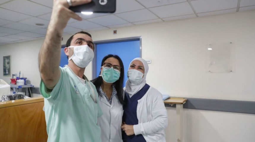 ممرضون يلتقطون صورة في مستشفى مخصص للكورونا
