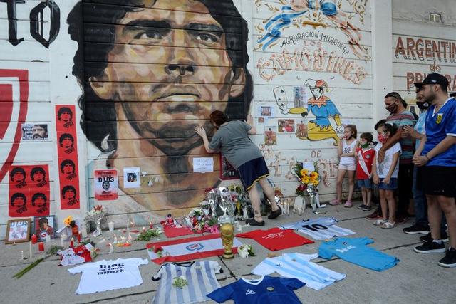 قمصان وقُبل على جدارية رسم عليها صورة مارادونا