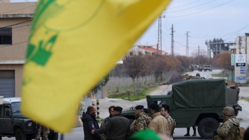 Hezbollah flag near Lebanese Armed Forces soldiers on Jan. 26 (AFP)