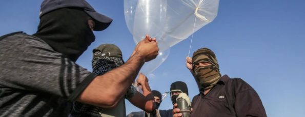 Palestinians attaching an incendiary device to inflated condoms to be flown toward Israel on Aug 21, 2020 (Getty)