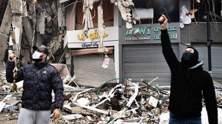 Two masked men fire celebratory shots into the air in Dahiyeh (Photo Credit_ NPR)