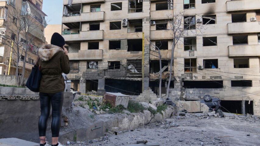 A woman checks a damaged building that was hit by Israeli airstrikes in central Beirut (AP)