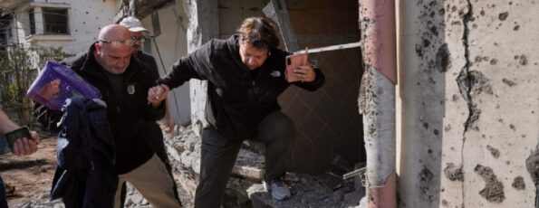 A woman gathers belongings from her family's home after it was damaged by a projectile launched from Lebanon, in Haniel, central Israel, Thursday, March 12, 2026 (AP)