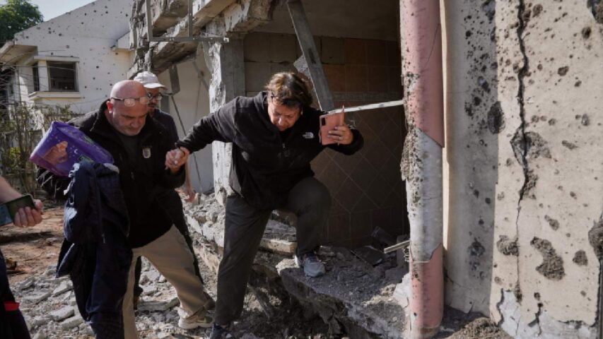 A woman gathers belongings from her family's home after it was damaged by a projectile launched from Lebanon, in Haniel, central Israel, Thursday, March 12, 2026 (AP)