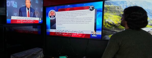 A Pakistani watches news channels telecasting report about Iran, the United States and Israel reaching a two-week ceasefire (AP)