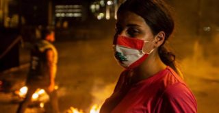 متظاهرة تضع كمامة للوقاية من فيروس كورونا مع عودة التظاهرات الى لبنان (EPA)